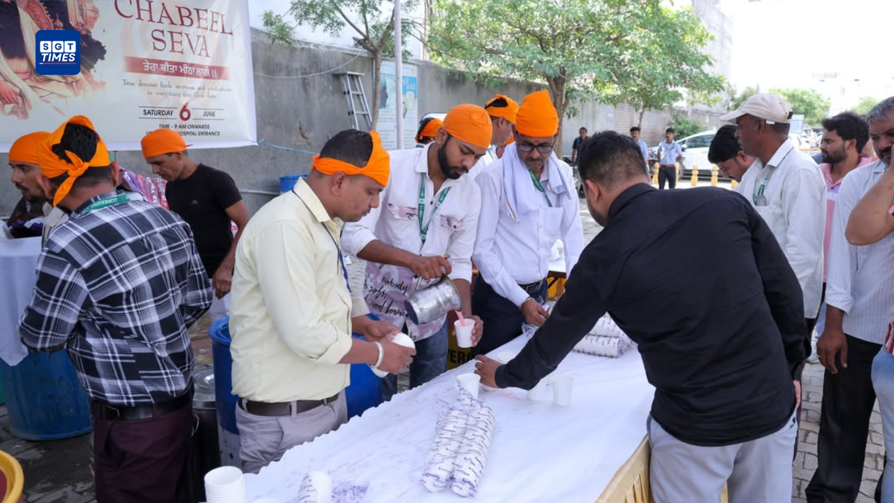 Students and staff at SGT University distributing sweet rosewater drinks during Chabeel Seva